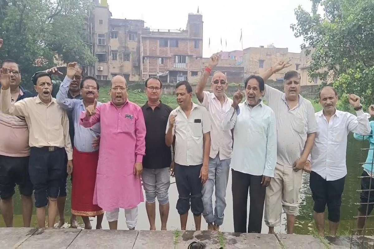 Dhanbad News : झरिया में पेयजल संकट, व्यापारियों ने तालाब में उतरकर जताया विरोध